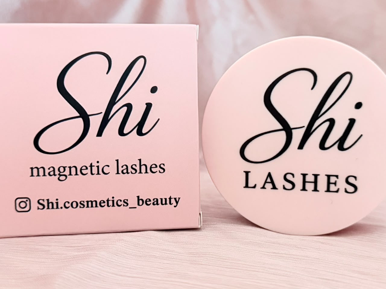 Shi Lashes magnetic lashes packaging box and circular compact on pink satin fabric